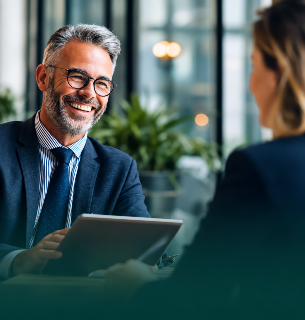 Smiling business advisor discussing financial solutions with a client in a modern office, representing business financing and professional financial consultation.